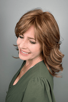 Woman wearing shoulder length brunette wig with bangs (Raquel Welch's On My Way wig in color Honey Toast) side