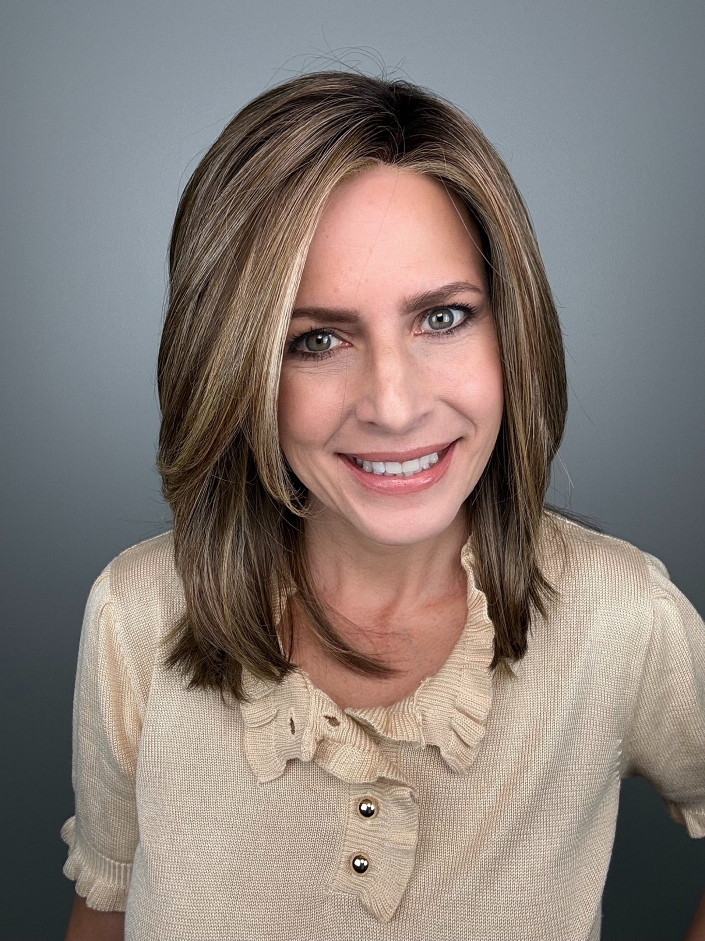 Woman with shoulder-length brown layered wig with side bangs (Own the Room by Gabor in Shaded Iced Cafe Latte)