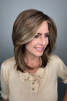 Woman with shoulder-length brown layered wig with side bangs (Own the Room by Gabor in Shaded Iced Cafe Latte)