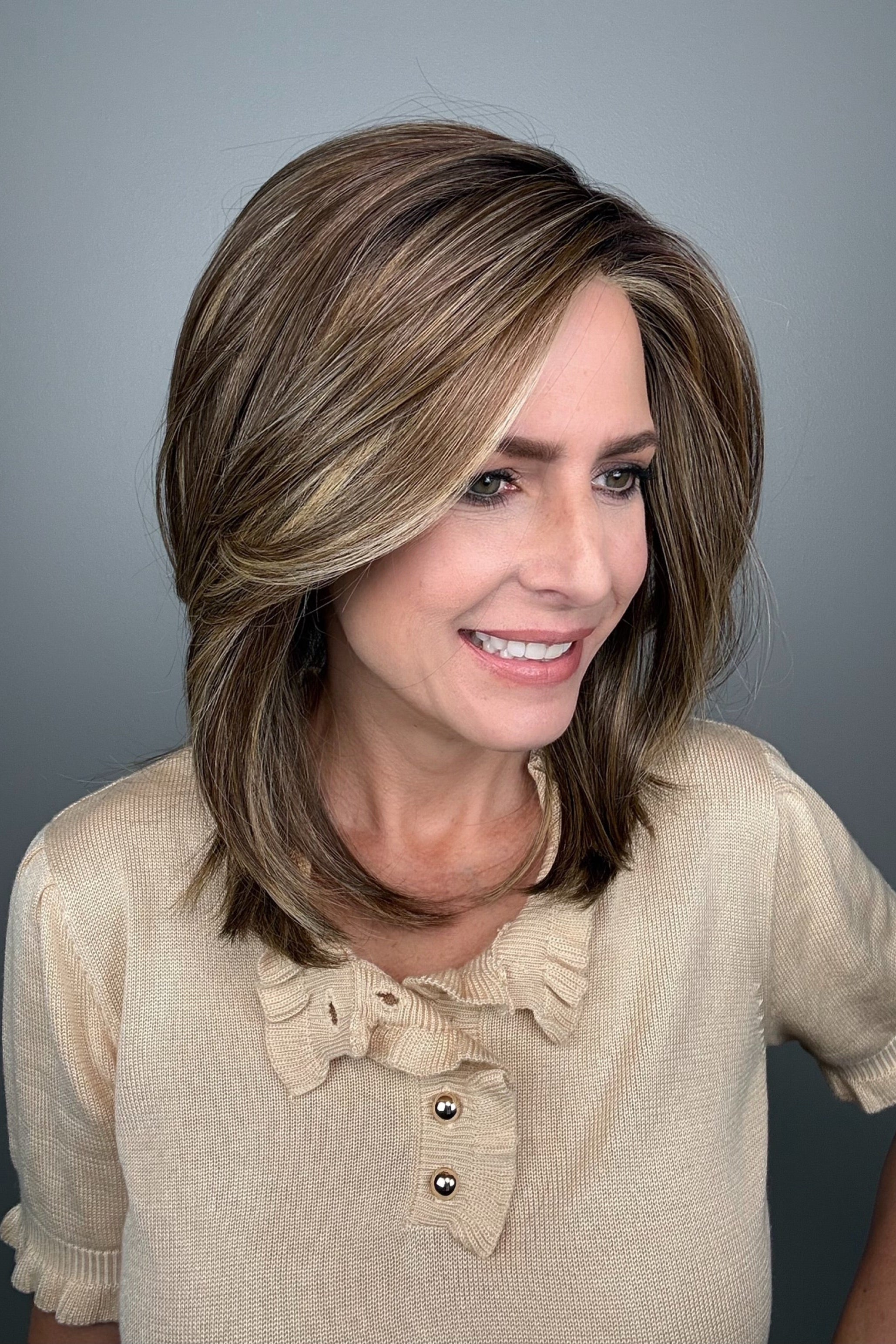 Woman with shoulder-length brown layered wig with side bangs (Own the Room by Gabor in Shaded Iced Cafe Latte)