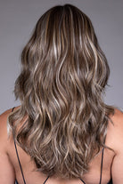 Back view of Poppy by Belle Tress, a mid-length heat-friendly synthetic wig with loose waves and highlighted brown hair.