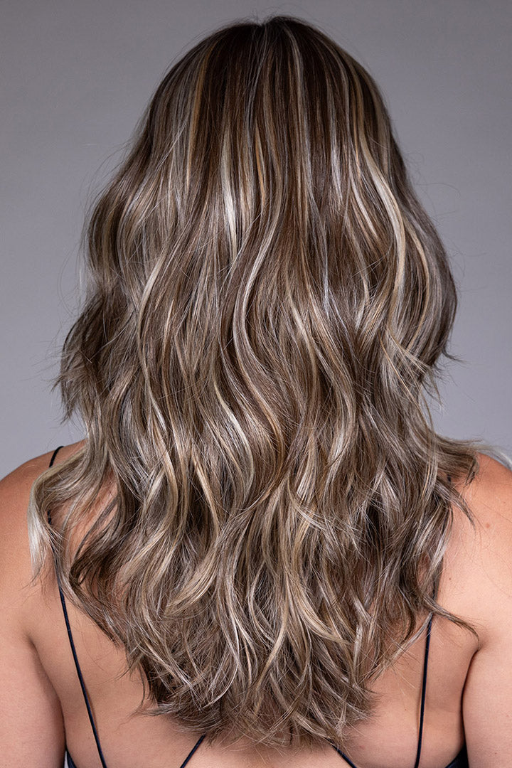 Back view of Poppy by Belle Tress, a mid-length heat-friendly synthetic wig with loose waves and highlighted brown hair.