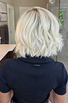 Woman wearing platinum blonde bob wig (Yvette by PUSH Hair in Bombshell Blonde). 