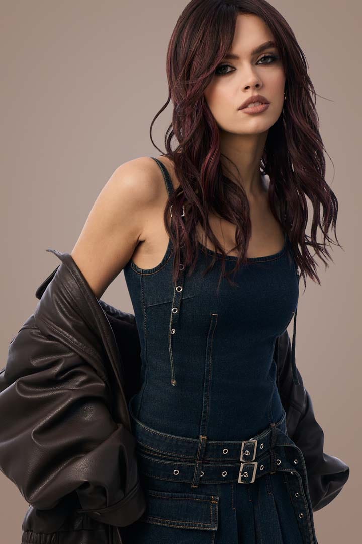 Woman in denim outfit with deep plum brown hair