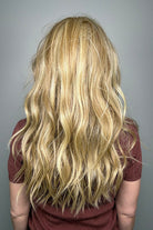 Woman with long blonde wavy wig (Posh Wavez by Rene of Paris in color Creamy Toffee) back
