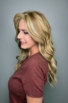 Woman with long blonde wavy wig (Posh Wavez by Rene of Paris in color Creamy Toffee) side
