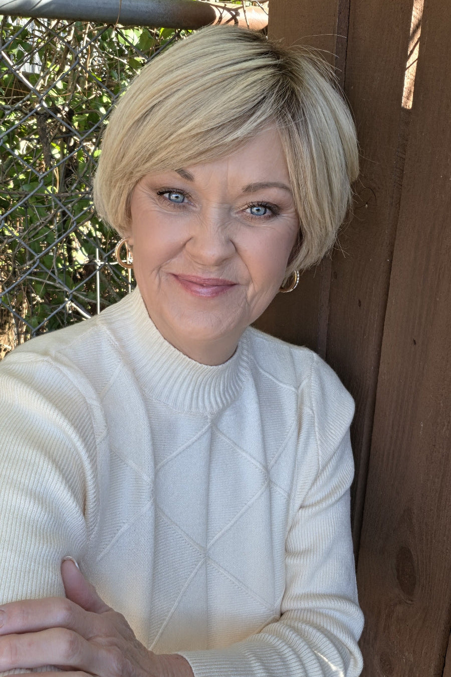 A woman with short blonde bixie wig (Emma by PUSH Hair in color Light Champagne Cream R).