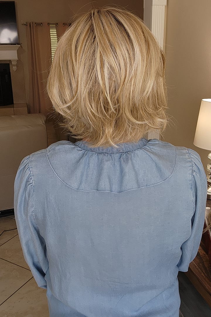 Woman wearing a blonde wavy bob wig (Brann by Rene of Paris in Seasalt Blonde R)
