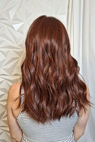 Woman with long wavy red wig (Decadent Diva by Raquel Welch in Deepest Ruby) back