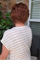 A woman with short reddish-brown hair wearing a white and beige horizontally striped short-sleeve top (Asha by Rene of Paris in color Cafe Rouge R).