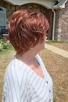 A woman with short reddish-brown hair wearing a white and beige horizontally striped short-sleeve top (Asha by Rene of Paris in color Cafe Rouge R).