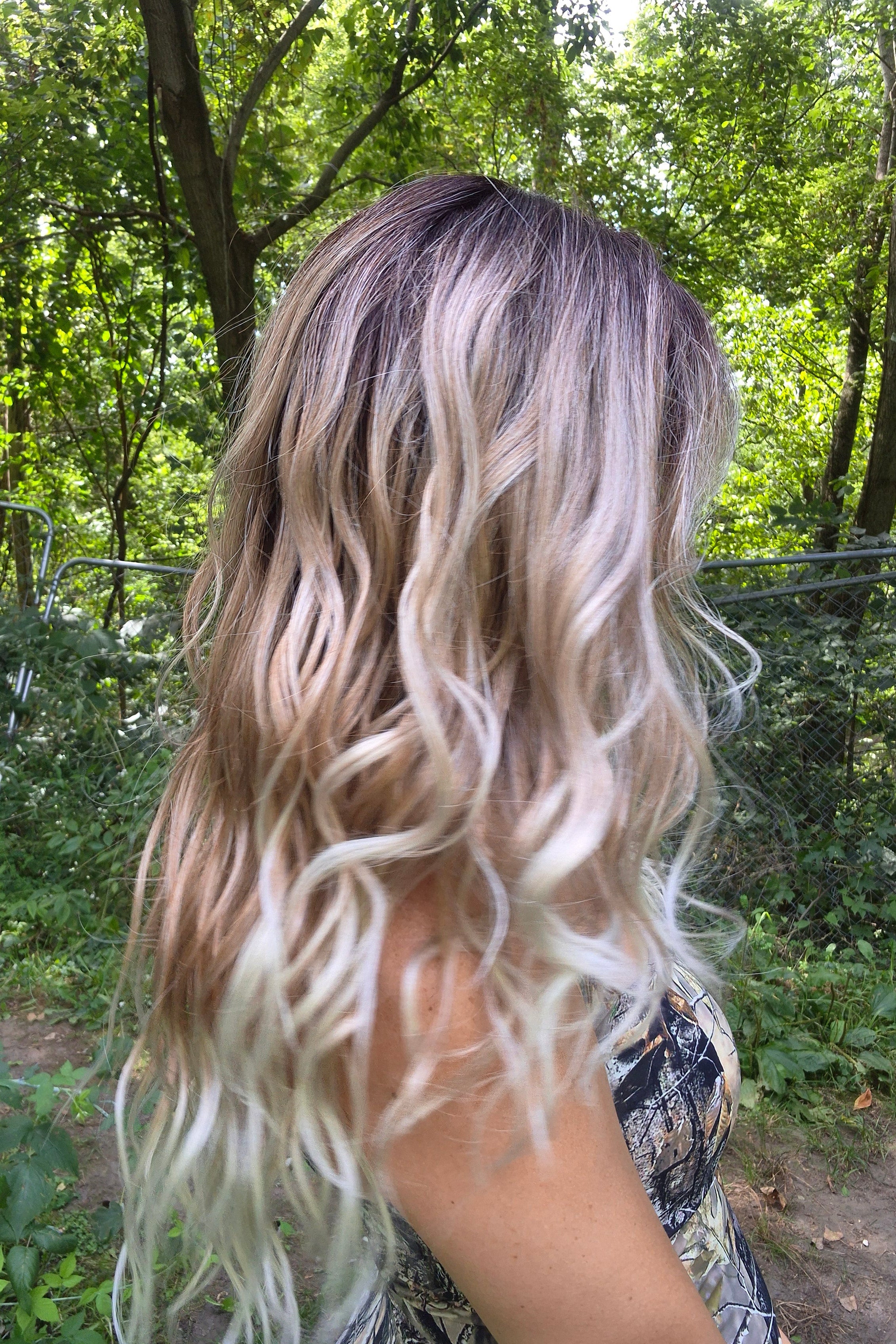 A woman with long blonde-highlighted hair wearing a camouflage-patterned tank top (Phillip by Rene of Paris in Melted Marshmallow R).
