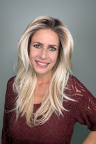 Woman wearing a long layered rooted blonde wig (Sizzle by TressAllure in Sand and Sun Lighted)