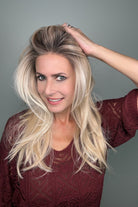 Woman wearing a long layered rooted blonde wig (Sizzle by TressAllure in Sand and Sun Lighted)