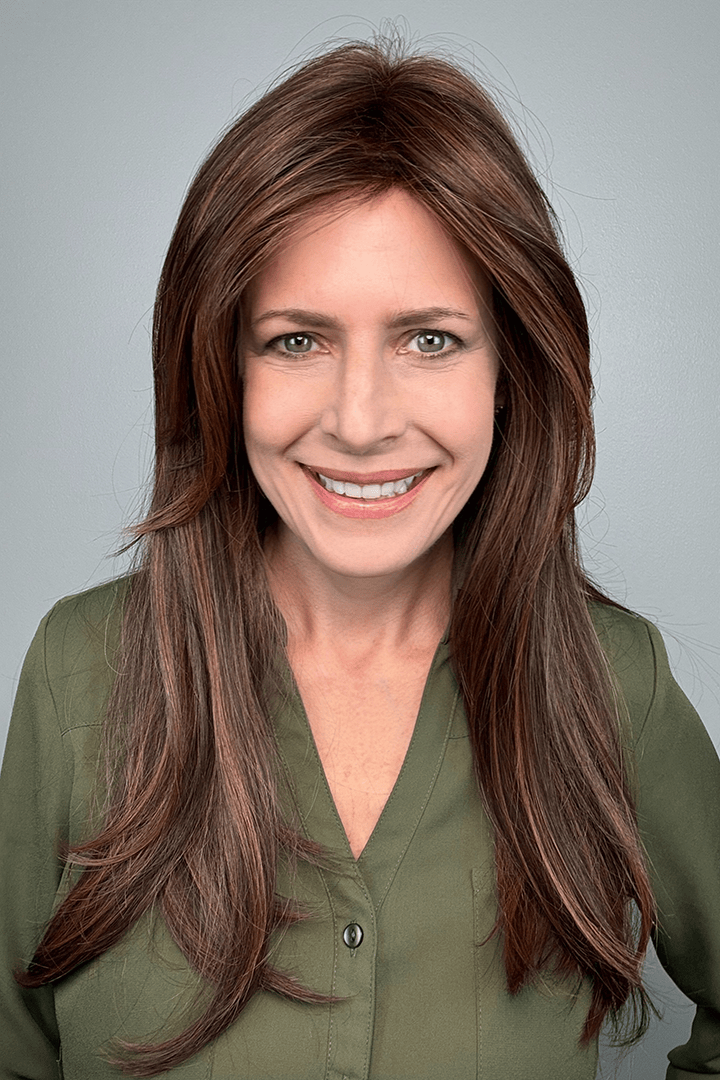 Woman wearing long layered wig with curtain bangs (Sleek Sophistication by Raquel Welch in color Copper Mahogany)