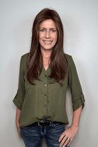 Woman wearing long layered wig with curtain bangs (Sleek Sophistication by Raquel Welch in color Copper Mahogany)