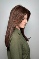 Woman wearing long layered wig with curtain bangs (Sleek Sophistication by Raquel Welch in color Copper Mahogany) side