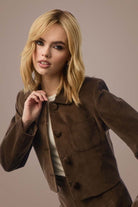 Woman with Smooth Wavez in Bronzed Honey wig and jacket.