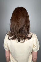 Woman wearing straight layered wig (Stephanie by WigPro in Pine Cone).