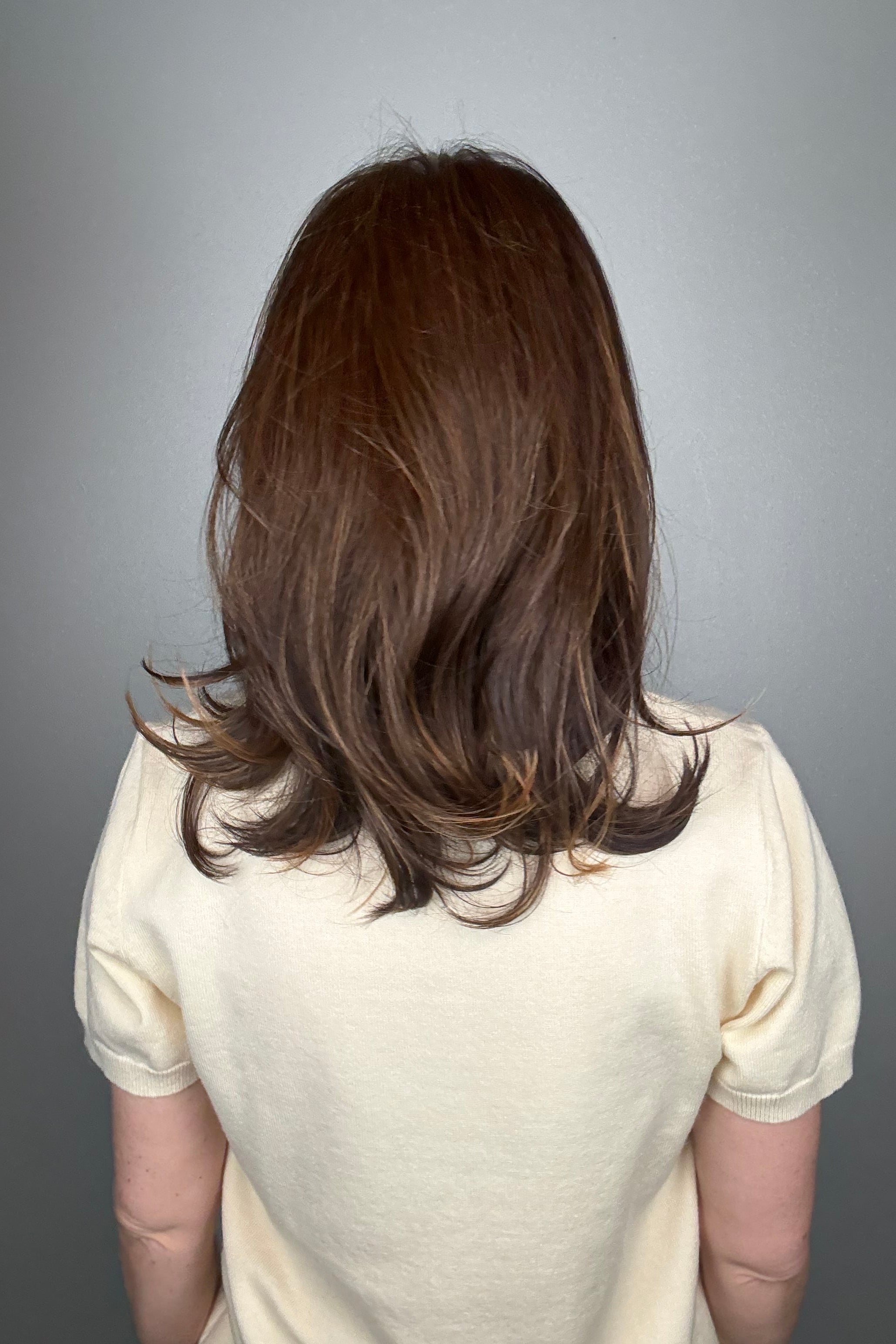 Woman wearing straight layered wig (Stephanie by WigPro in Pine Cone).
