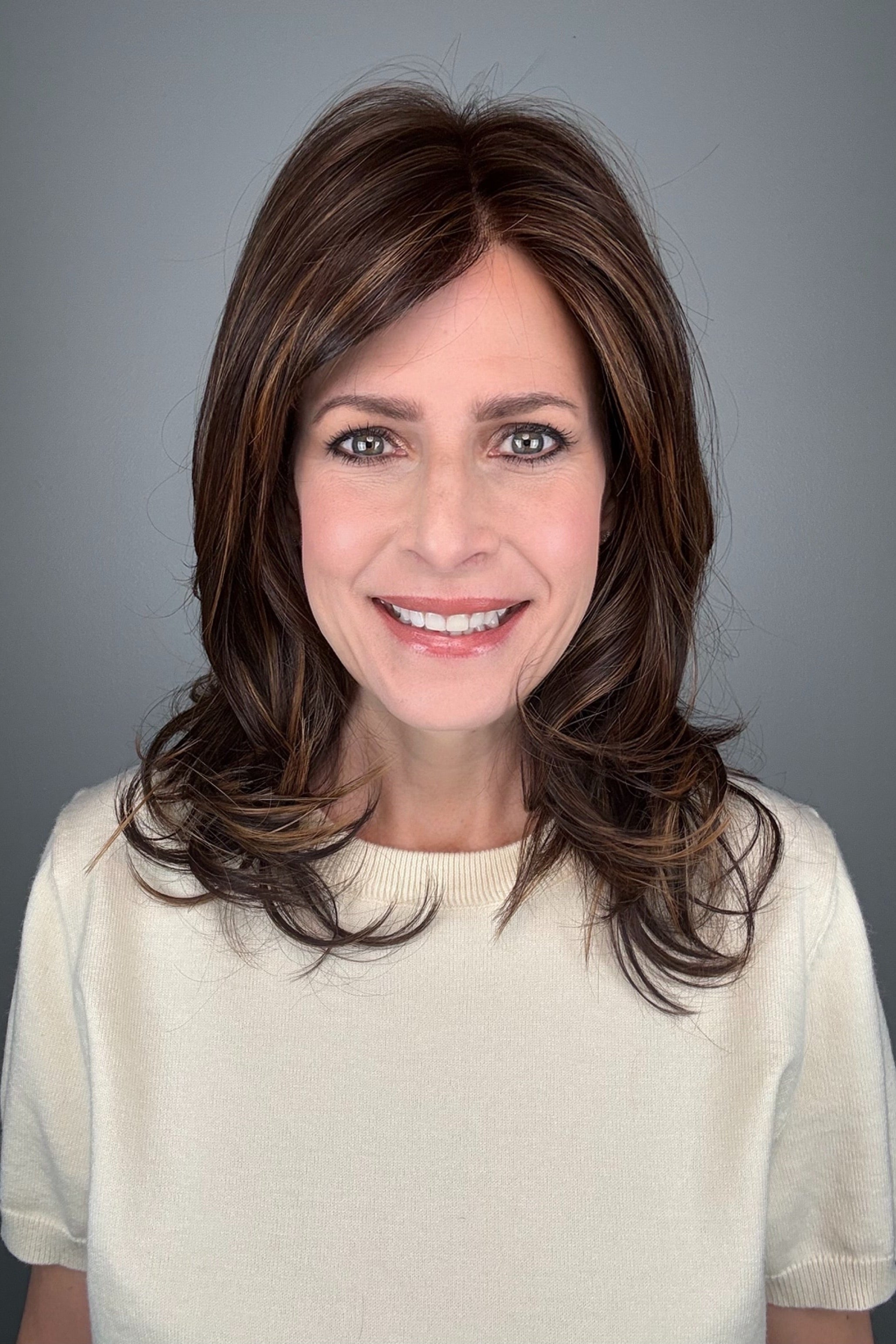 Woman wearing straight layered wig (Stephanie by WigPro in Pine Cone).