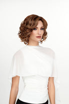 Woman wearing She's Like the Wind synthetic lace front wig by TressAllure in color 17/23/R8 with a white top and white background. Front view.