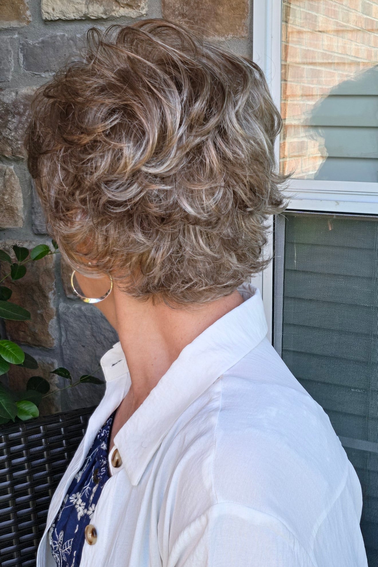 A woman with short textured blonde wig (Kenzie by Tony of Beverly in Silverstone).