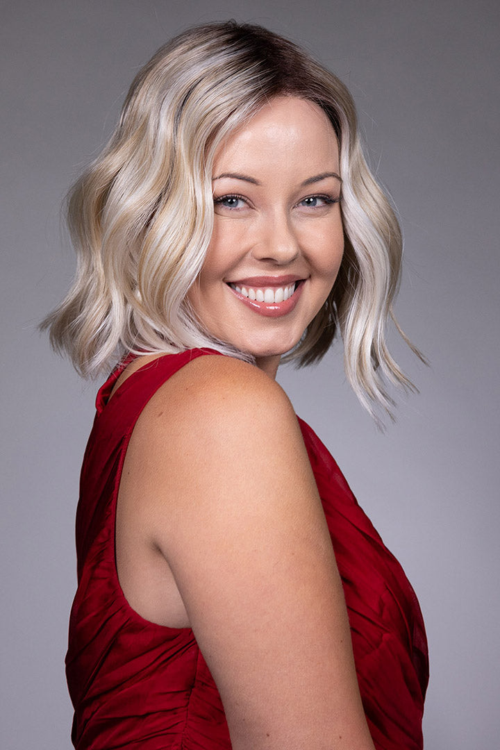 Tulip by Belle Tress chin-length blonde bob wig with soft waves, center part, and money piece highlights.