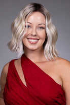 Tulip by Belle Tress chin-length blonde wavy bob wig with a center part and face-framing money piece highlights.