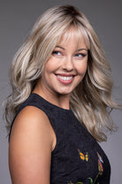 Vesper by Belle Tress blonde layered shag wig with wispy bangs and a natural lace front monofilament top.