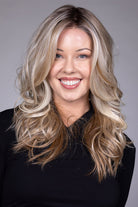 Wisteria by Belle Tress long wavy synthetic wig with face-framing blonde money piece highlights and a lace front.