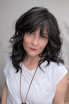 Woman wearing curly shouldar length (Belle Tress' Westwood in Coolest Dark Brown R)