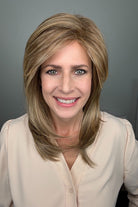 Woman wearing layered golden blonde wig with bangs (Whisper by Henry Margu in 12/26H)
