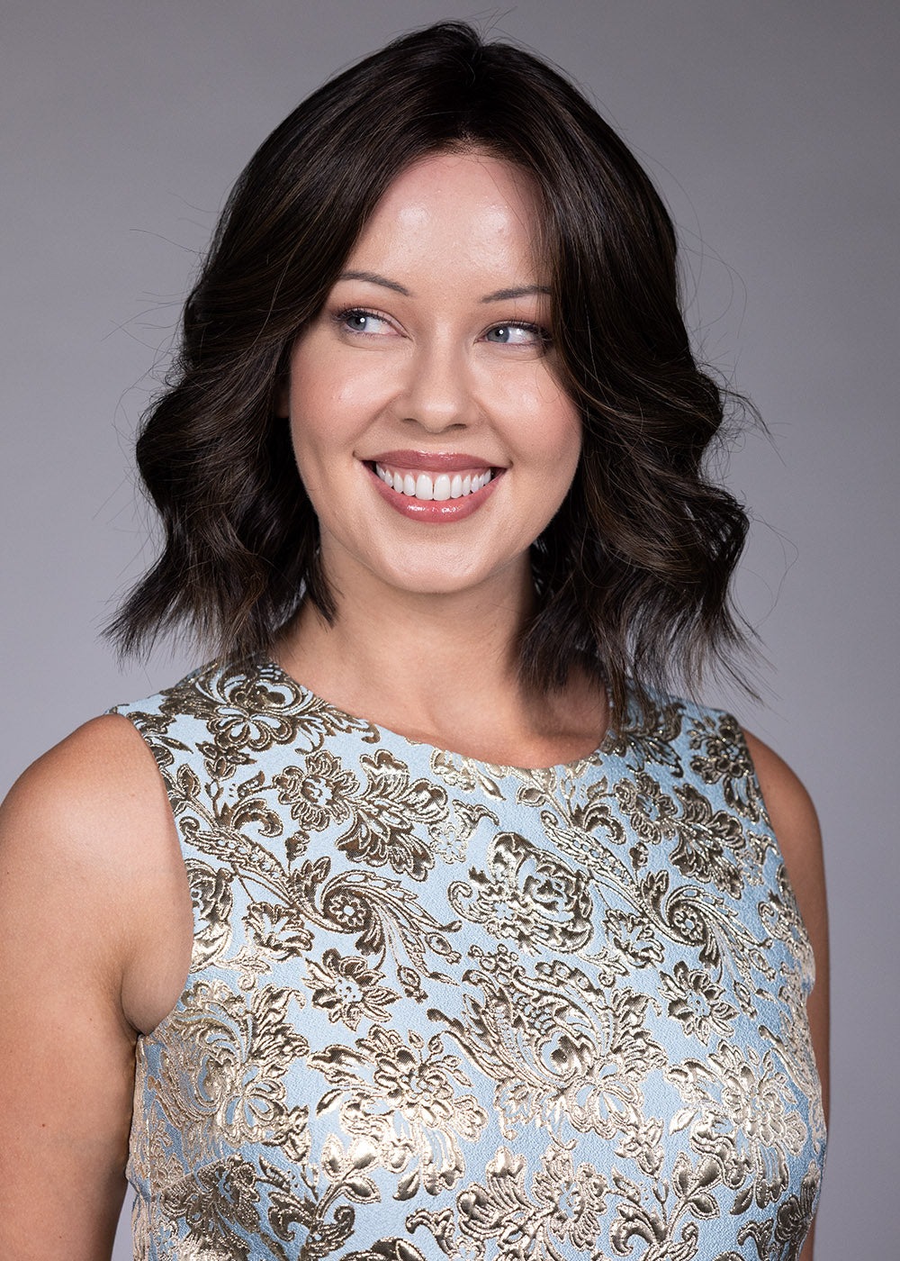 Woman wearing Zurich wig by Belle Tress in Triple Chocolate R | Front smiling looking to side