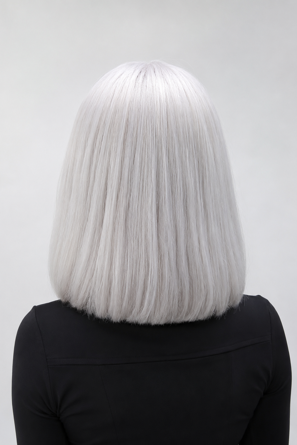 Woman wearing Bespoke 12" Human Hair Wig by PUSH in color Blanche against a plain background - Back view.