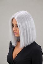 Woman wearing Bespoke 12" Human Hair Wig by PUSH in color Blanche against a plain background - Left side view.