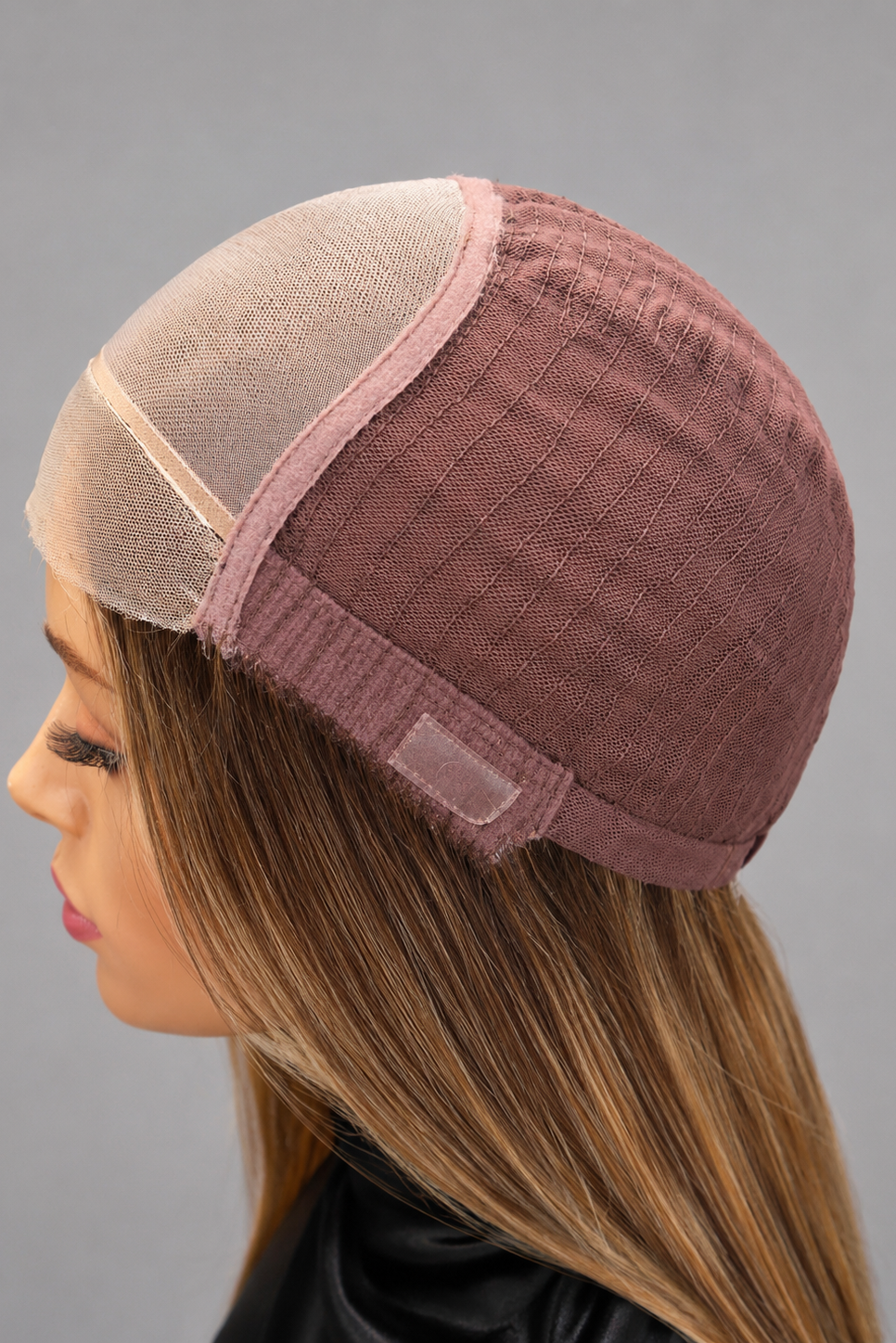 Woman wearing wig turned inside out to show side of wig cap construction.
