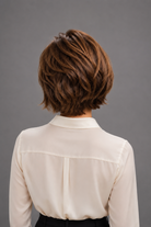 Woman wearing Bespoke Human Hair Wig by PUSH in color Noisette with a button down cream blouse. Back view.