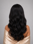 Woman wearing 24" long wavy human hair wig by PUSH Hair in color Noir - Back view.