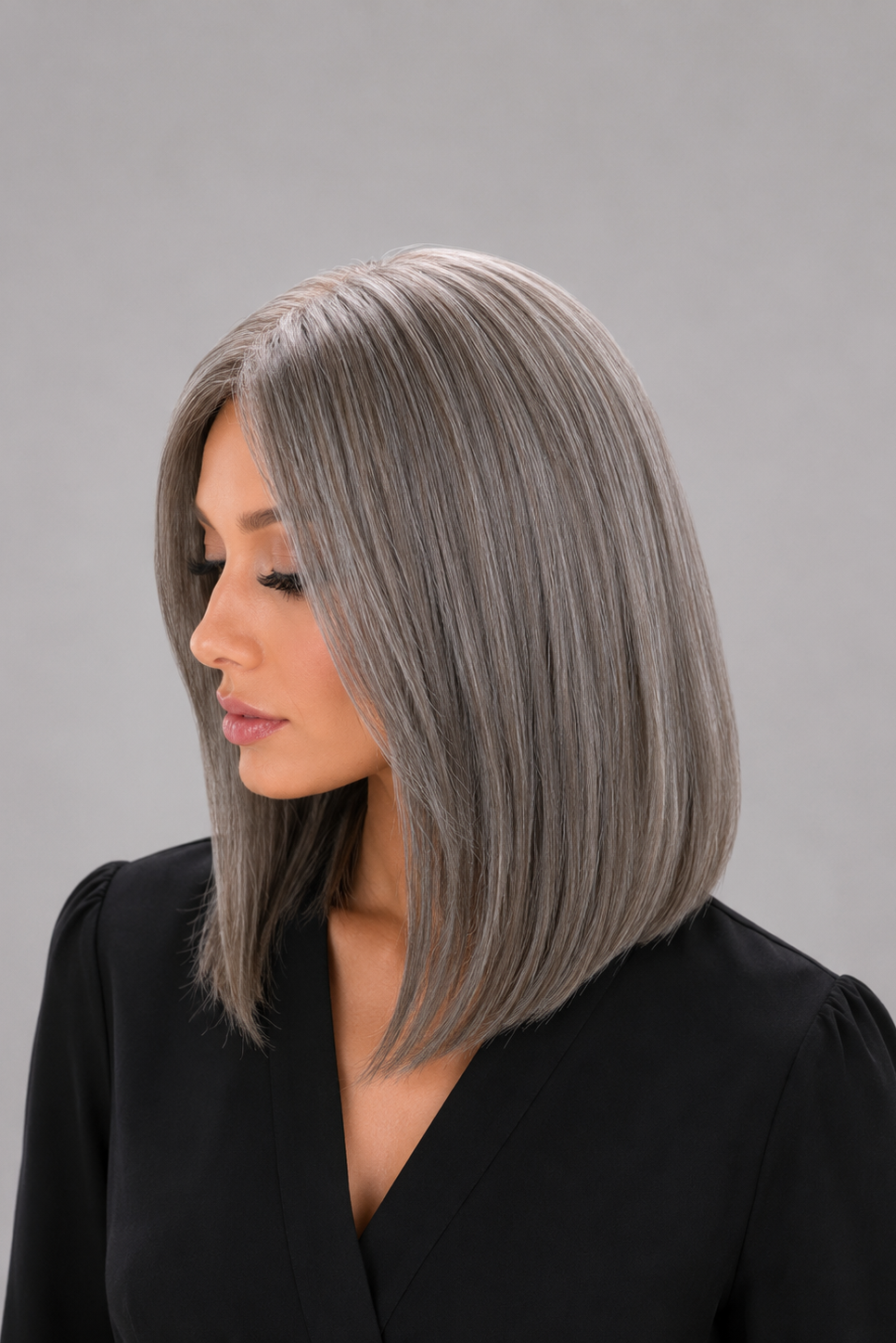 Woman wearing Bespoke human hair wig by PUSH - 16" inverted bob wig in color sage with a black blouse against a light grey background - left side view
