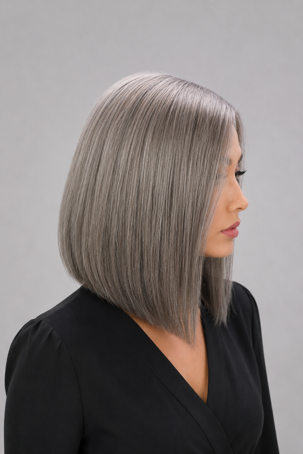 Woman wearing Bespoke human hair wig by PUSH - 16" inverted bob wig in color sage with a black blouse against a light grey background - right side view