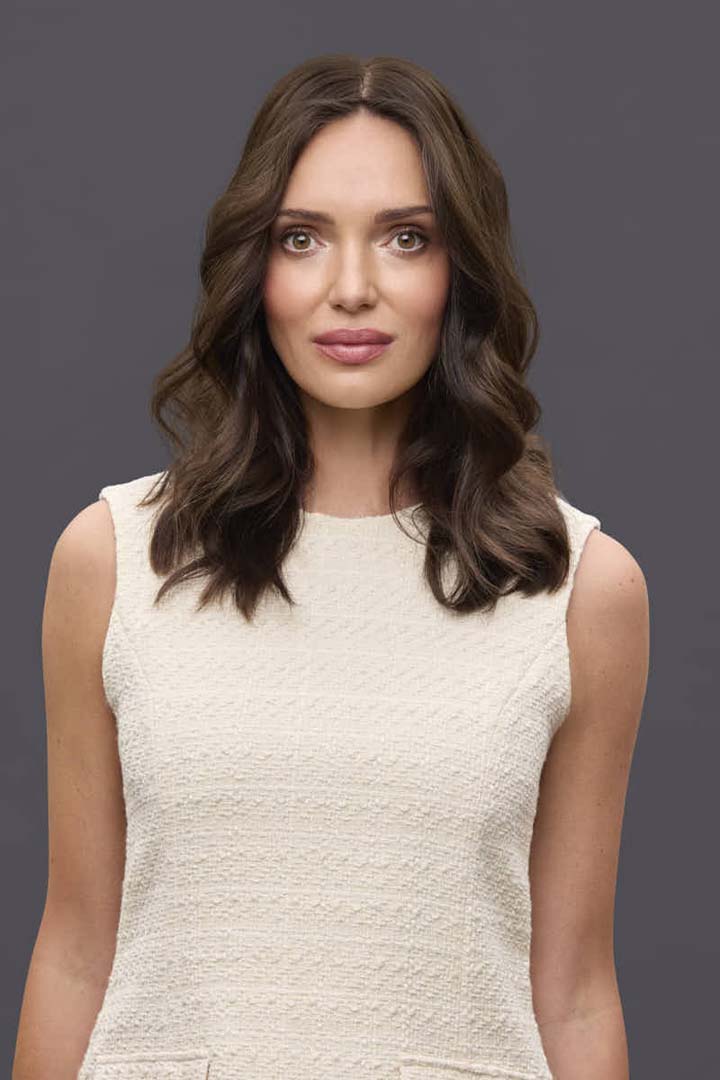Model wearing 14-inch brown Remy human hair topper with a natural center part and soft, wavy texture.