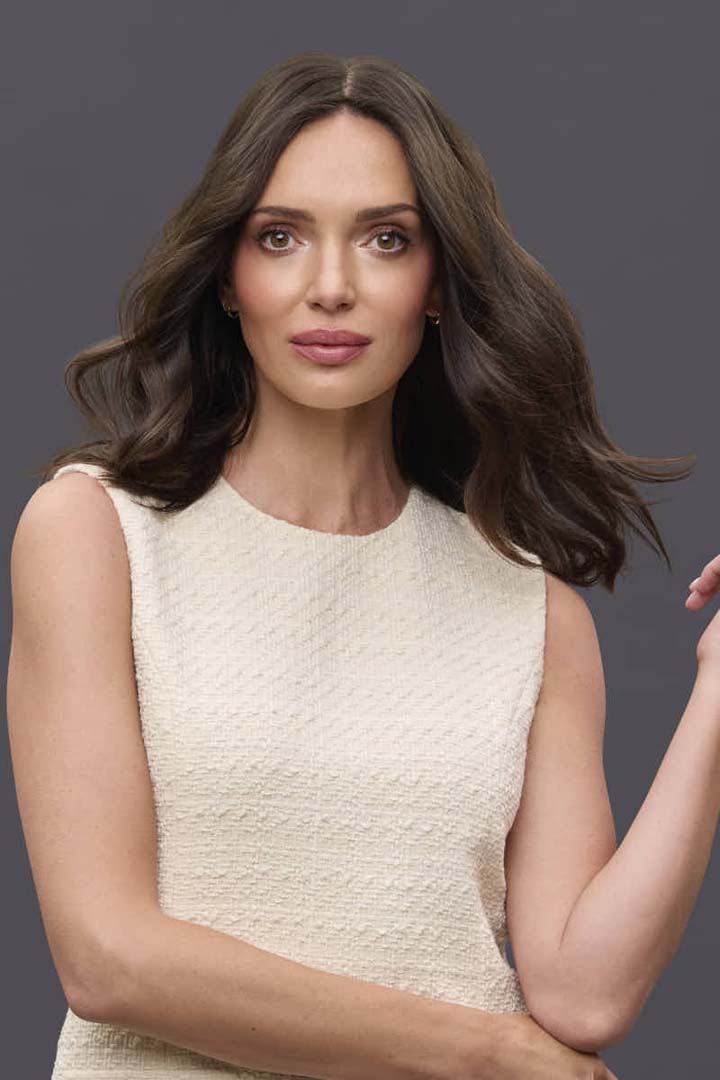 Woman wearing a 14-inch brown Remy human hair topper with a natural part and soft waves for lightweight coverage.