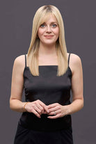 Woman wearing a 14-inch blonde Remy human hair topper with a natural monofilament base and soft bangs.