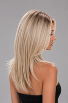 Woman wearing Evangeline heat friendly synthetic long wig in color pearl silk rooted and a strapless black dress against a light grey background. Right side view.