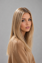 Woman wearing Remmie human hair wig by PUSH Hair in color champagne creme rooted and a tan sweater against a light grey background - right side view