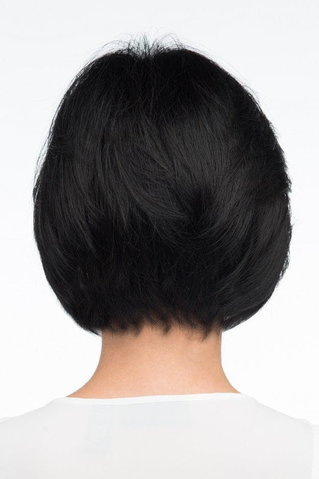 A woman wearing Abbey by Envy - A Human Hair and Heat Friendly Synthetic Blend wig in color black with a white sleeveless top against a white background. Back view.